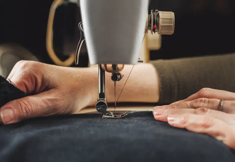 Hands sewing fabric with machine