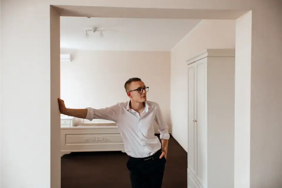 Man leaning in a minimalist room.